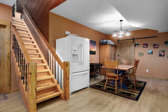 8403 Lawrence Unit 1040, La Russell, MO 64848 - dining space featuring a barn door, stairway, wood finished floors, lofted ceiling, and baseboards