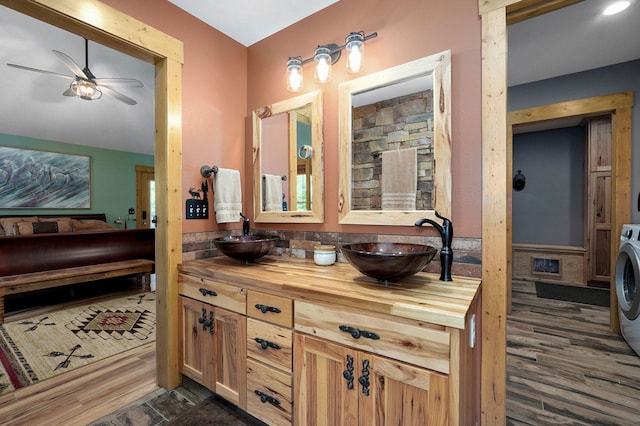 8403 Lawrence Unit 1040, La Russell, MO 64848 - ensuite bathroom featuring double vanity, ceiling fan, washer / dryer, wood finished floors, and a wainscoted wall