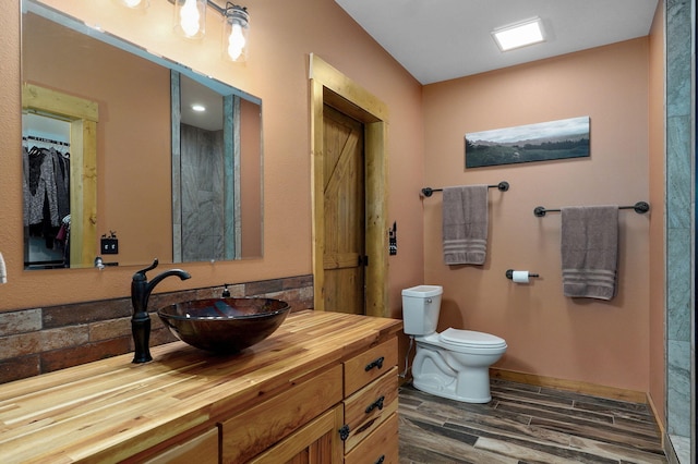 8403 Lawrence Unit 1040, La Russell, MO 64848 - full bathroom featuring toilet, wood finished floors, vanity, and baseboards