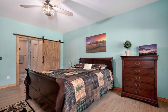 8403 Lawrence Unit 1040, La Russell, MO 64848 - bedroom with light wood-type flooring, a barn door, and baseboards