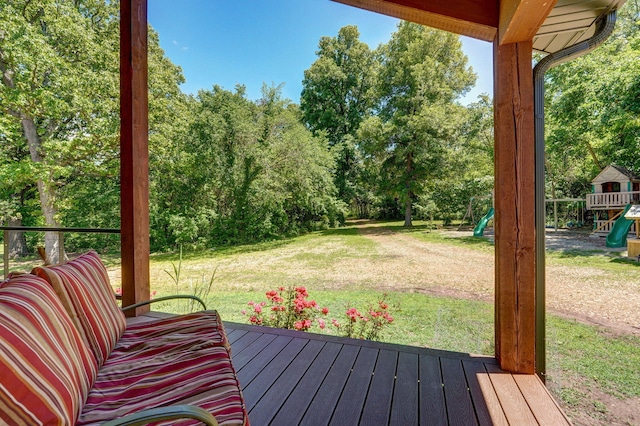 8403 Lawrence Unit 1040, La Russell, MO 64848 - wooden terrace featuring a playground, a lawn, and view of wooded area