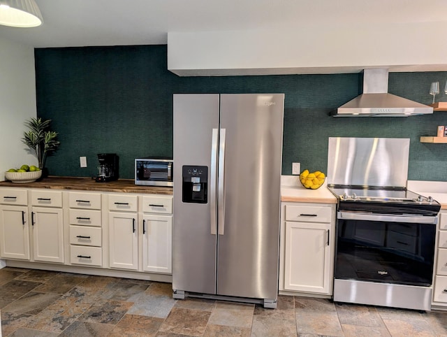 280 Wimbledon Dr Unit 8, Branson, MO 65616 - kitchen featuring stainless steel appliances, wall chimney range hood, stone finish flooring, and white cabinetry