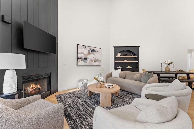 280 Wimbledon Dr Unit 8, Branson, MO 65616 - living room with a large fireplace, a high ceiling, baseboards, and light wood-type flooring