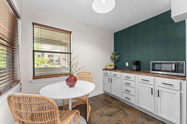 280 Wimbledon Dr Unit 8, Branson, MO 65616 - dining space with stone tile floors, baseboards, and an accent wall