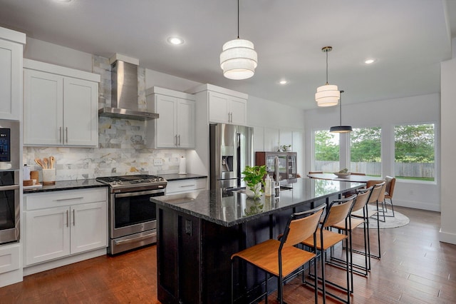 735 N Fox Hill Cir, Nixa, MO 65714 - kitchen with stainless steel appliances, wall chimney range hood, backsplash, a breakfast bar, and an island with sink