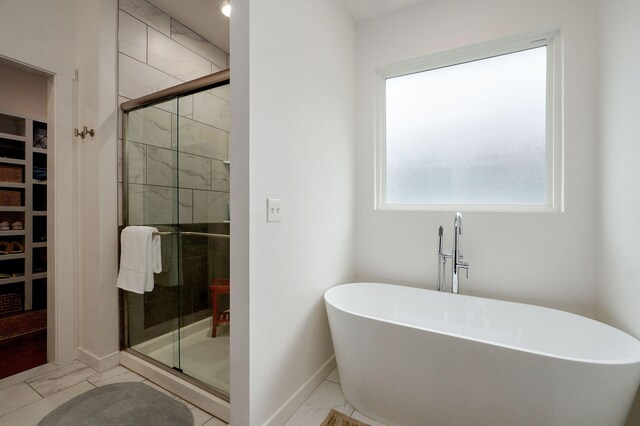 735 N Fox Hill Cir, Nixa, MO 65714 - full bath with marble finish floors, a freestanding tub, a shower stall, and baseboards