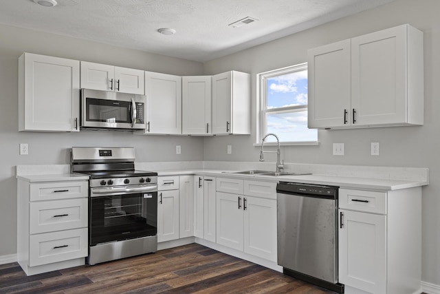 1079 Wiseman Rd, Marshfield, MO 65706 - kitchen featuring stainless steel appliances, a sink, dark wood finished floors, and white cabinets
