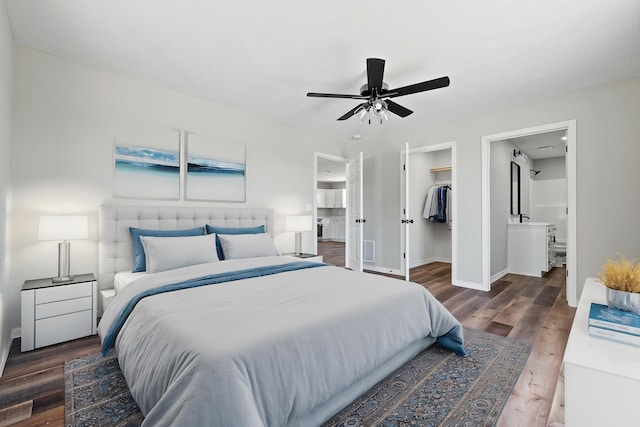 1079 Wiseman Rd, Marshfield, MO 65706 - bedroom featuring wood finished floors, a walk in closet, baseboards, a closet, and connected bathroom