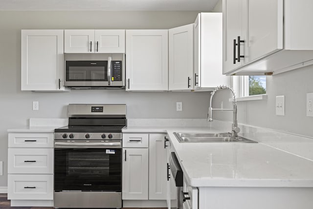 1079 Wiseman Rd, Marshfield, MO 65706 - kitchen featuring appliances with stainless steel finishes, a sink, white cabinets, and light countertops