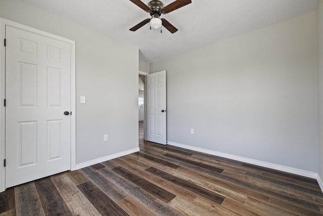 1079 Wiseman Rd, Marshfield, MO 65706 - unfurnished bedroom featuring dark wood-style flooring, baseboards, and a ceiling fan