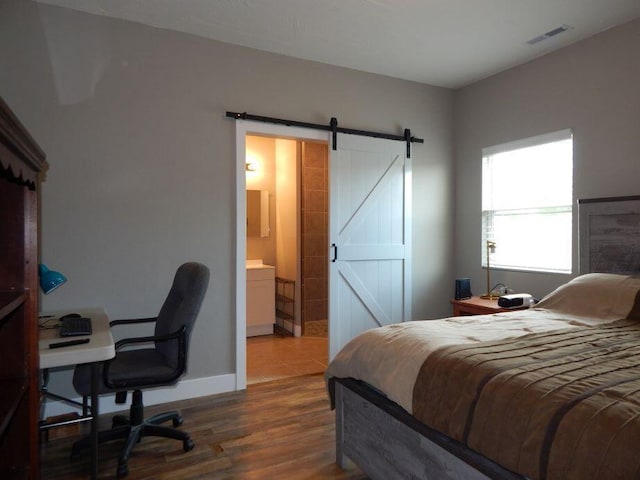 510 Kenny St, Ava, MO 65608 - bedroom with a barn door, a desk, wood finished floors, baseboards, and connected bathroom