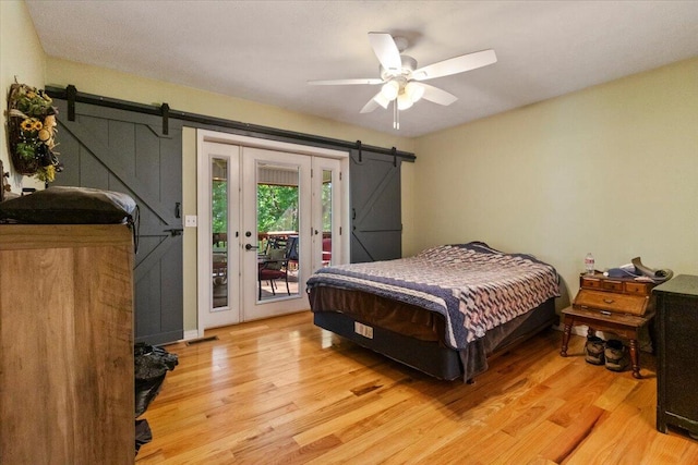 657 Plentywood Ln, Gainesville, MO 65655 - bedroom with a barn door, access to exterior, light wood-type flooring, and a ceiling fan