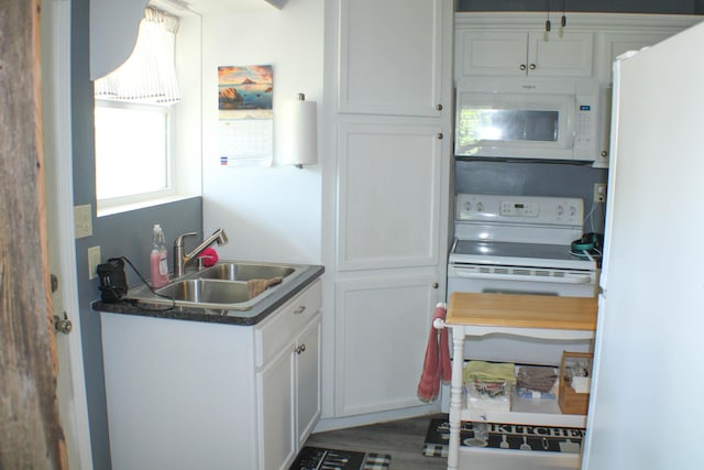 821 NW B Hwy, Osceola, MO 64776 - kitchen featuring white appliances, a sink, white cabinets, and dark countertops