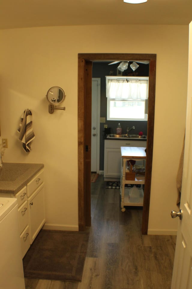 821 NW B Hwy, Osceola, MO 64776 - bathroom featuring wood finished floors, a sink, baseboards, and washer / clothes dryer