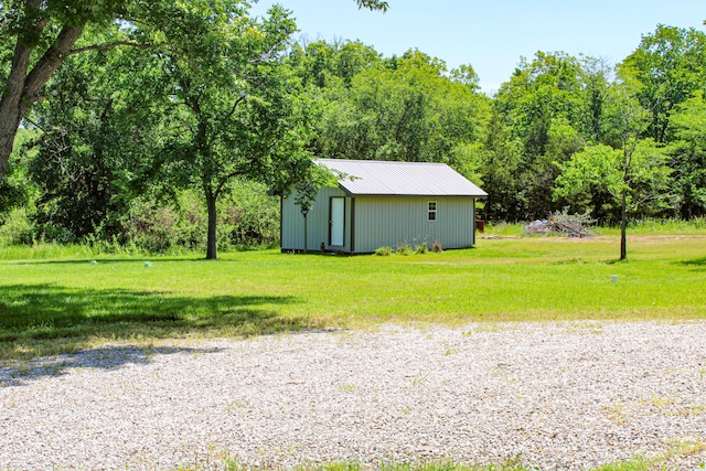 821 NW B Hwy, Osceola, MO 64776 - view of green lawn with an outdoor structure, a pole building, and a forest view