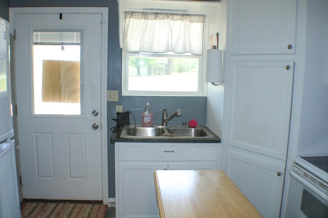 821 NW B Hwy, Osceola, MO 64776 - kitchen featuring a sink, white cabinetry, and white electric stove