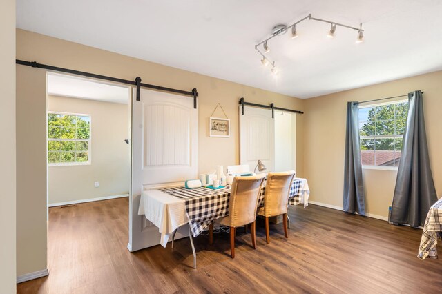 485 Eagle Dr, Forsyth, MO 65653 - dining area featuring a barn door, dark wood finished floors, plenty of natural light, and baseboards