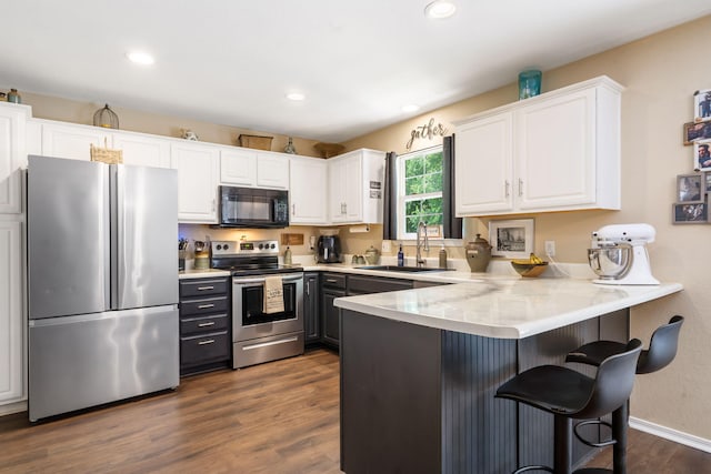 485 Eagle Dr, Forsyth, MO 65653 - kitchen with stainless steel appliances, a sink, white cabinets, a peninsula, and dark wood-style flooring