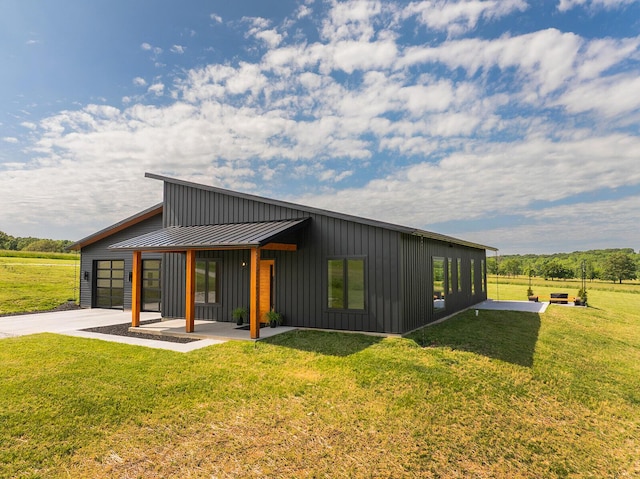 13213 State Highway M, Billings, MO 65610 - back of house with a standing seam roof, board and batten siding, concrete driveway, a metal roof, and a lawn