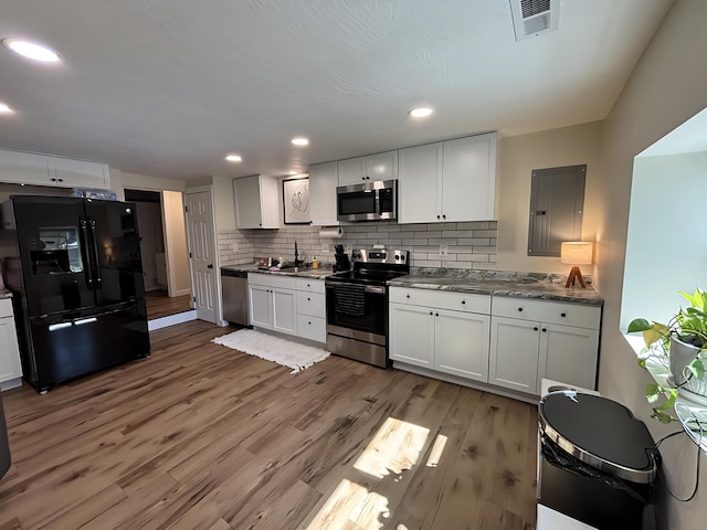 2510 W Madison St, Springfield, MO 65802 - kitchen with appliances with stainless steel finishes, a sink, tasteful backsplash, light wood-style flooring, and electric panel