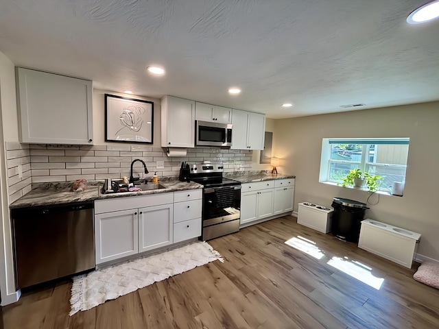 2510 W Madison St, Springfield, MO 65802 - kitchen with stainless steel appliances, a sink, decorative backsplash, light wood-type flooring, and recessed lighting