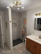 411 N Main St, Diamond, MO 64840 - full bath featuring a chandelier, vanity, and a tile shower