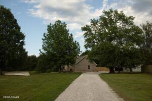 411 N Main St, Diamond, MO 64840 - view of home's community featuring a lawn and asphalt driveway