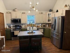 411 N Main St, Diamond, MO 64840 - kitchen with stainless steel appliances, vaulted ceiling, white cabinetry, a center island, and a chandelier