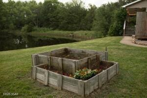 411 N Main St, Diamond, MO 64840 - view of grassy yard featuring a garden and a forest view