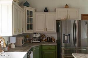 411 N Main St, Diamond, MO 64840 - kitchen with stainless steel fridge, a sink, light countertops, and glass insert cabinets