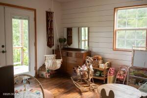 411 N Main St, Diamond, MO 64840 - living area with plenty of natural light, wood finished floors, and wood walls