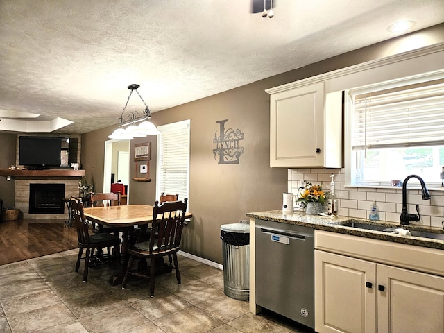 512 E Slim Wilson Blvd, Nixa, MO 65714 - kitchen with dishwasher, a sink, a fireplace, tasteful backsplash, and pendant lighting