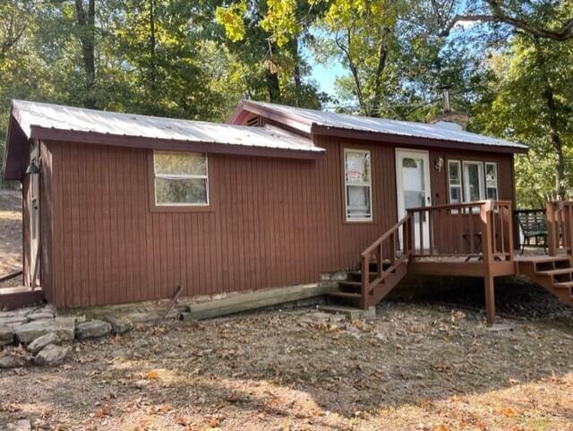 2382 Minnow Dr, Omaha, AR 72662 - view of front of home with a wooden deck, metal roof, and a chimney