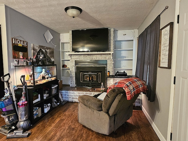 22182 County Road 288, Pittsburg, MO 65724 - living room with a textured ceiling, wood finished floors, a fireplace, built in shelves, and baseboards