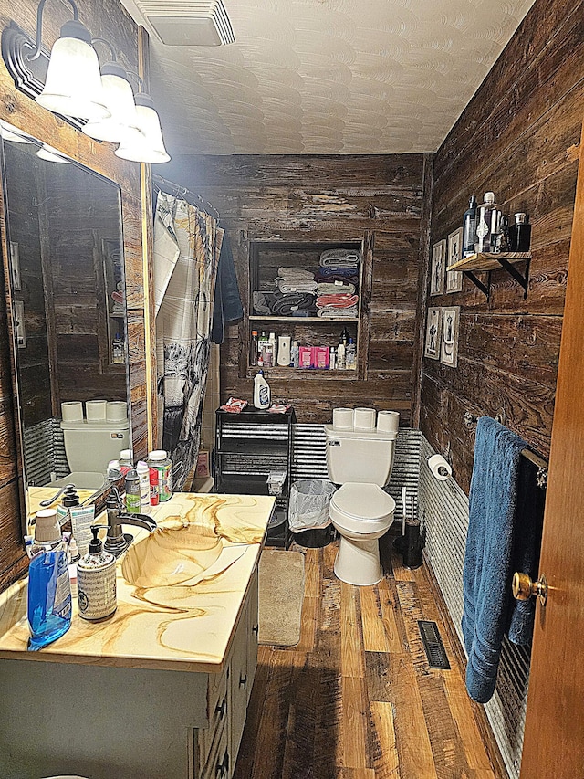 22182 County Road 288, Pittsburg, MO 65724 - bathroom featuring toilet, wood finished floors, wooden walls, vanity, and a chandelier