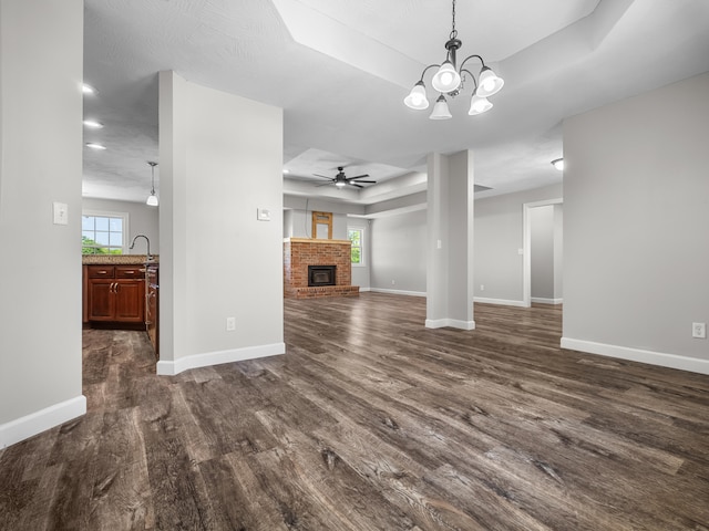 8863 Serene Acres Ln, Rogersville, MO 65742 - unfurnished living room featuring a tray ceiling, dark wood-type flooring, ceiling fan, a fireplace, and recessed lighting