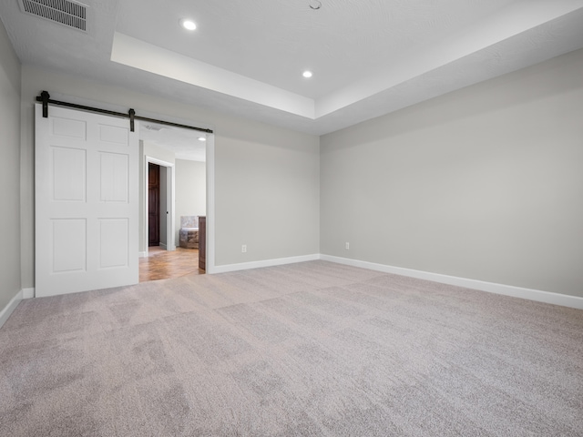 8863 Serene Acres Ln, Rogersville, MO 65742 - unfurnished bedroom featuring light carpet, baseboards, recessed lighting, a raised ceiling, and a barn door