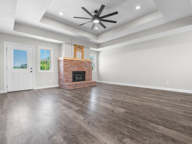 8863 Serene Acres Ln, Rogersville, MO 65742 - unfurnished living room featuring a tray ceiling, baseboards, dark wood-type flooring, recessed lighting, and a ceiling fan