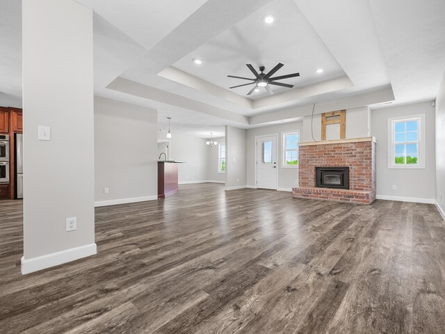 8863 Serene Acres Ln, Rogersville, MO 65742 - unfurnished living room featuring a tray ceiling, baseboards, ceiling fan, dark wood-style flooring, and recessed lighting