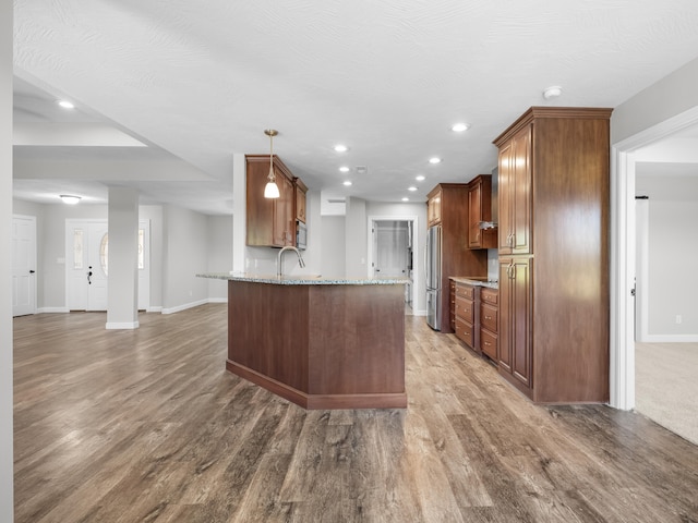 8863 Serene Acres Ln, Rogersville, MO 65742 - kitchen featuring stainless steel appliances, baseboards, wood finished floors, light stone counters, and a peninsula
