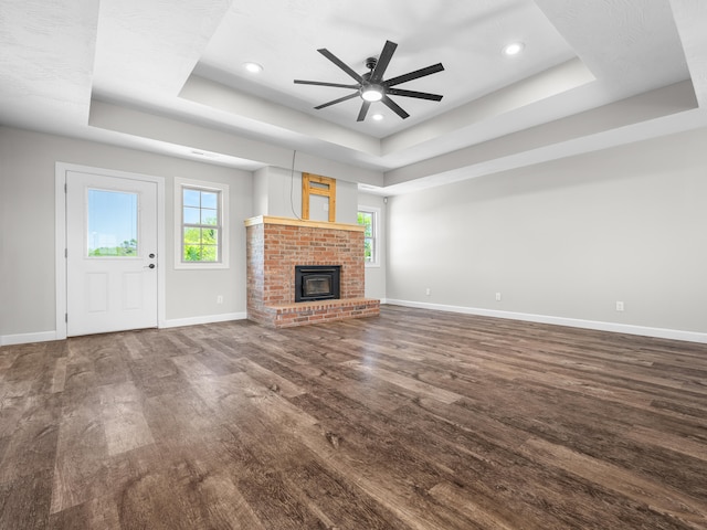 8863 Serene Acres Ln, Rogersville, MO 65742 - unfurnished living room featuring a tray ceiling, healthy amount of natural light, wood finished floors, baseboards, and recessed lighting