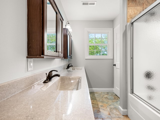 8863 Serene Acres Ln, Rogersville, MO 65742 - bathroom featuring double vanity, baseboards, stone finish floors, and enclosed tub / shower combo