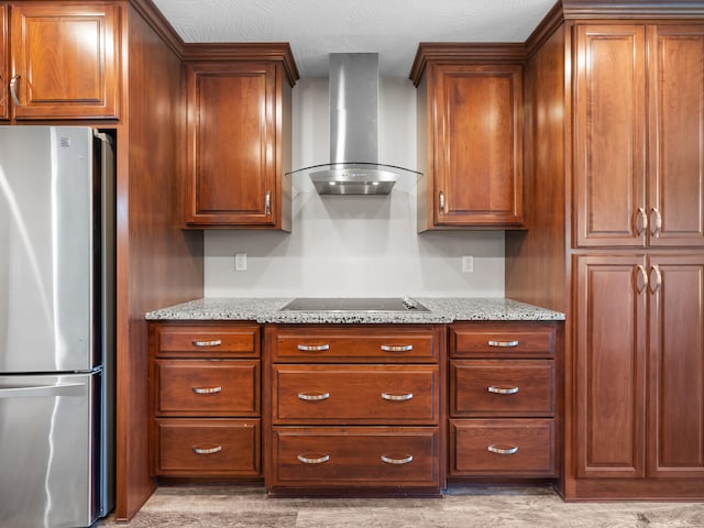 8863 Serene Acres Ln, Rogersville, MO 65742 - kitchen featuring freestanding refrigerator, wall chimney range hood, black electric cooktop, and light stone countertops