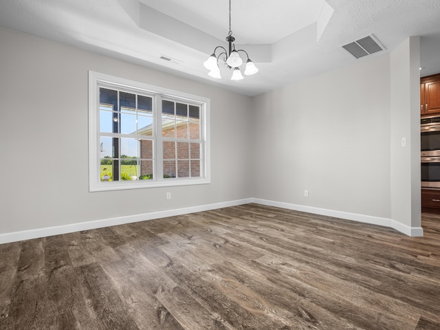 8863 Serene Acres Ln, Rogersville, MO 65742 - empty room featuring a raised ceiling, dark wood-type flooring, a chandelier, and baseboards