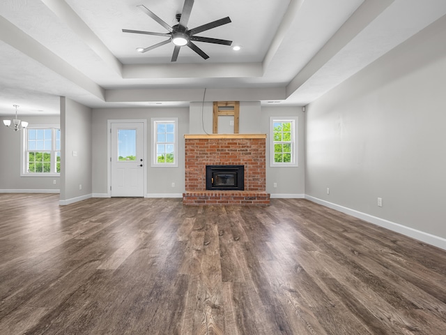 8863 Serene Acres Ln, Rogersville, MO 65742 - unfurnished living room featuring a raised ceiling, wood finished floors, a brick fireplace, and baseboards