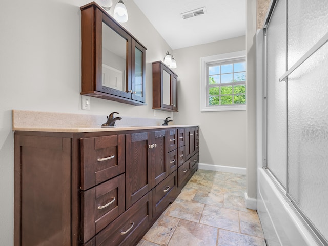 8863 Serene Acres Ln, Rogersville, MO 65742 - full bathroom featuring double vanity, baseboards, stone finish floors, and bath / shower combo with glass door