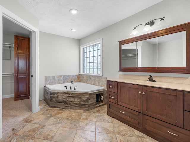 8863 Serene Acres Ln, Rogersville, MO 65742 - bathroom with vanity, a bath, a walk in closet, and recessed lighting