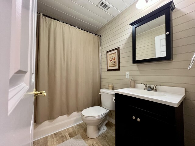 1207 Ledgestone Cir, Branson West, MO 65737 - bathroom with wooden walls, vanity, toilet, and shower / tub combo