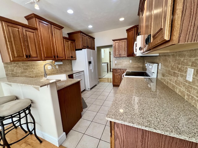 1207 Ledgestone Cir, Branson West, MO 65737 - kitchen featuring a sink, white appliances, a peninsula, tasteful backsplash, and recessed lighting
