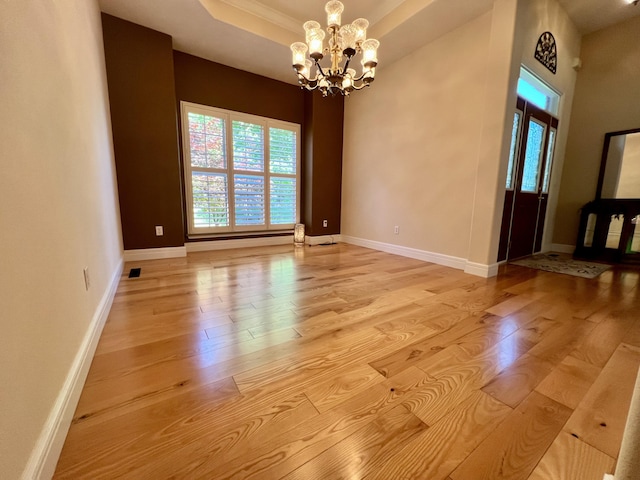 1207 Ledgestone Cir, Branson West, MO 65737 - unfurnished room featuring light wood-type flooring, a chandelier, a tray ceiling, and baseboards